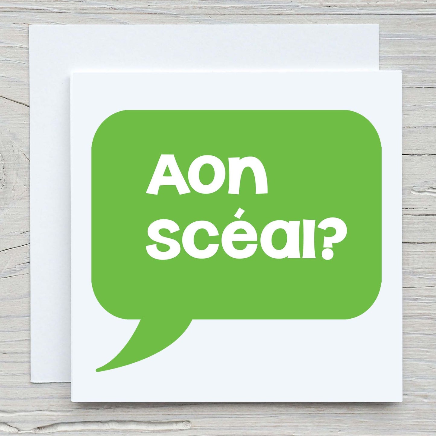 Irish greeting card and envelope with words Aon scéal? written in a speech bubble. Translates to Any News?