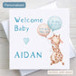 Welcome to the World Baby boy card with illustration of a giraffe holding balloons and showing baby's name.