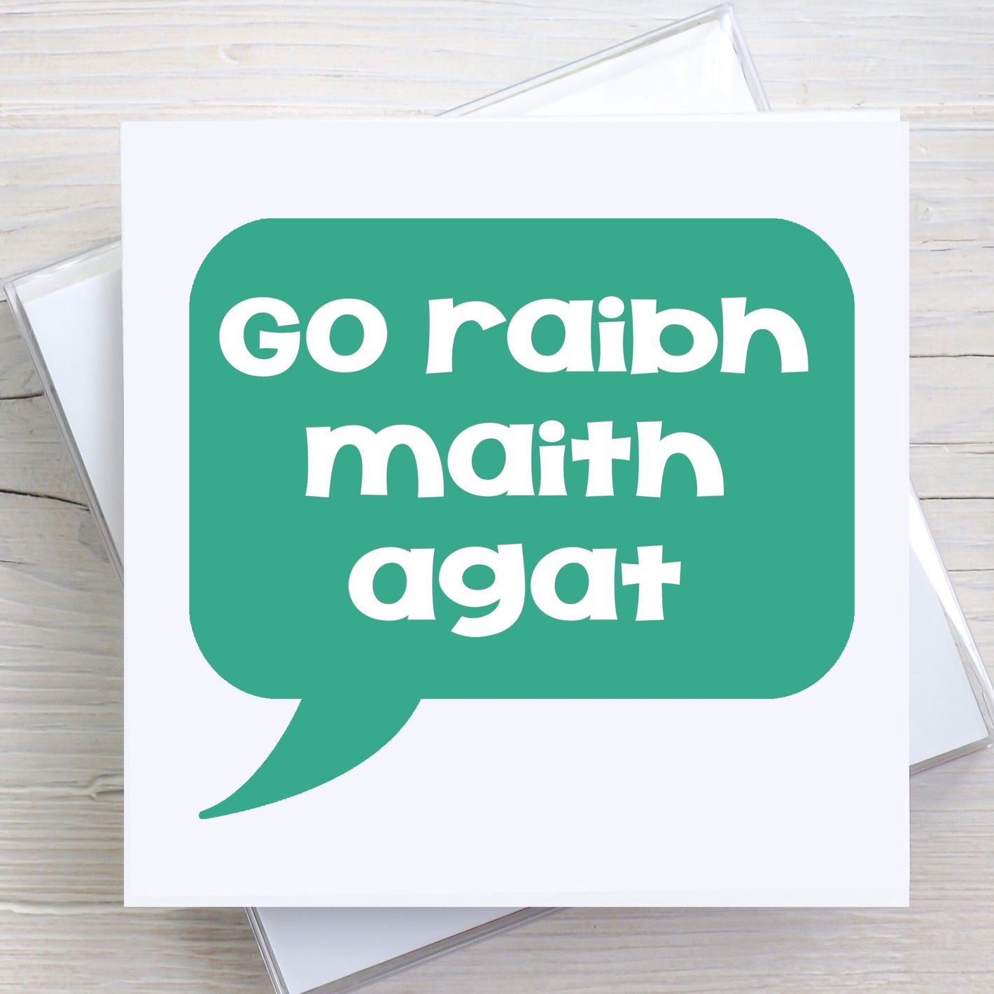 Irish greeting card with words Go Raibh Maith Agat written in a green speech bubble.  Translates to Thank You, as gaeilge.
